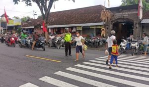 Polisi Lalulintas Membantu Masyarakat Menyebrang Jalan