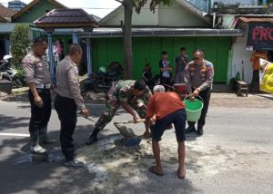 Polisi Bersama TNI dan Warga Tambal Jalan Berlubang di Kota Malang Cegah Kecelakaan