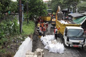 PEMKOT SURABAYA GERAK CEPAT PERBAIKI PELAPIS TANGGUL JEBOL PENYEBAB BANJIR DI MAYJEN SUNGKONO