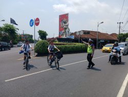 Aiptu Gede Wirawan Bantu Sebrangkan Anak Sekolah