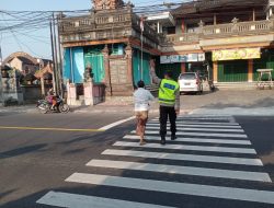 Berbuat Kebaikan, Petugas Polsek Mengwi Bantu Warga Sebrangkan Jalan